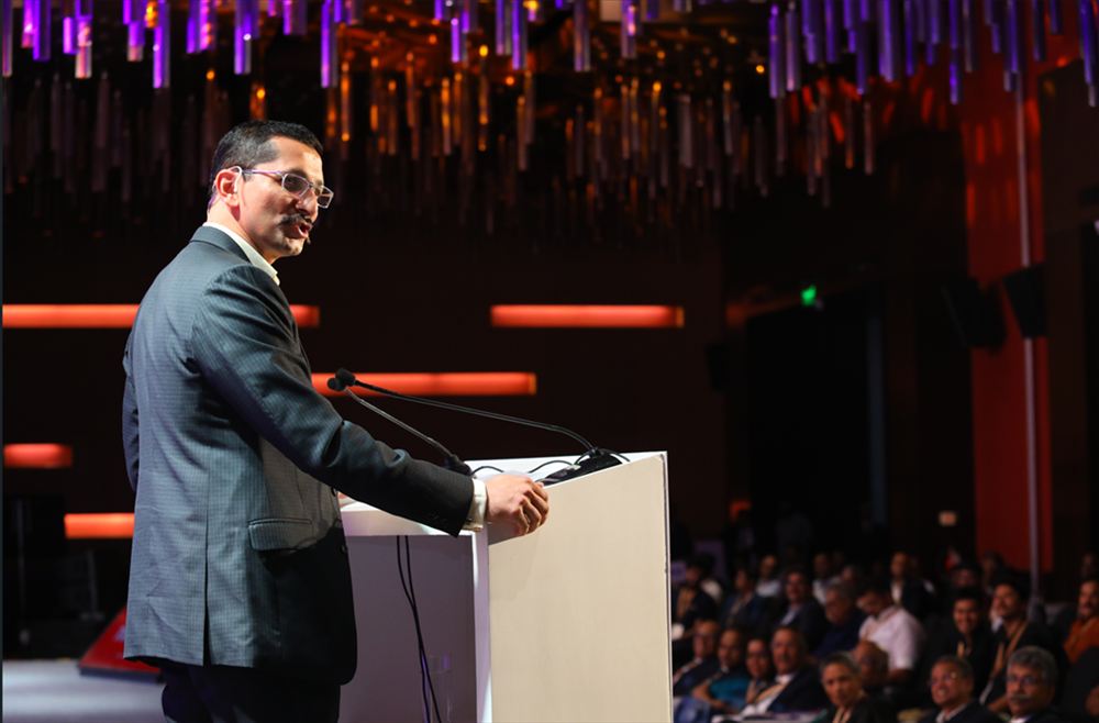 Chinmay delivering a keynote from the podium to a large audience
