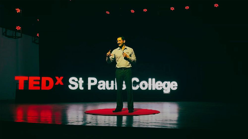 Chinmay speaking on the red circle at TEDx St Pauls College